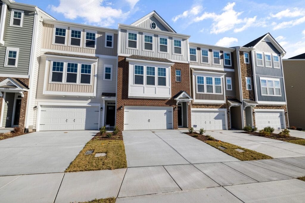 A row of new townhouses with double garages and concrete driveways on a Vaughan street